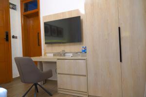 a bathroom with a desk with a television on a wall at The Lemiray Hotel in Dodoma +64 photos