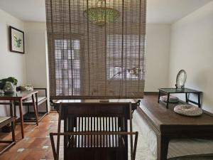 a living room with a table and chairs and a window at Farm Cottage in Hong Kong +10 photos