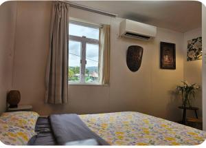 a bedroom with a bed and a window at Farm Cottage in Hong Kong