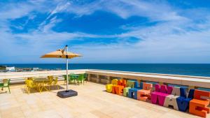 a patio with a table and chairs and an umbrella at 온더웨이브호텔 in Taesong