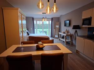 ein Wohnzimmer mit einem Bett und einem Tisch mit Stühlen in der Unterkunft B&B Fragaria in Hoogstraten