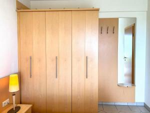 a large wooden cabinet in a room with a lamp at Strandvilla Therese Appartment 5 in Norderney