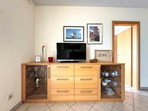 a television on a wooden cabinet in a room at Strandvilla Therese Appartment 5 in Norderney