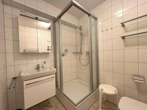 a bathroom with a shower and a toilet and a sink at Strandvilla Therese Appartment 5 in Norderney +12 photos