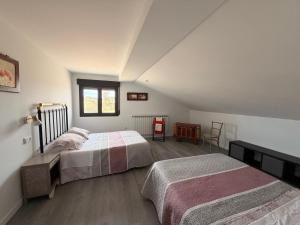 a bedroom with two beds and a table and window at Campos de Villalba in Villalba +72 photos