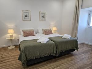 a bedroom with two beds and two lamps onlishes sidx sidx sidx sidx at The Yellow Cottage in Lomba de São Pedro