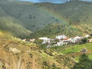 a rainbow over a village on a hill at Casita Tomate in Granada