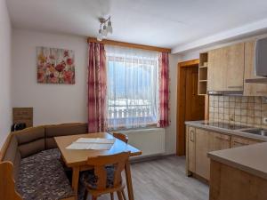 a kitchen and living room with a table and a couch at Rauterhof in Hermagor