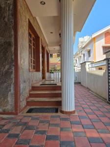 a building with a column on a sidewalk at Spacious 2 Bedroom Private House in Mangalore Fully Air-Conditioned, WiFi & Parking in Mangalore