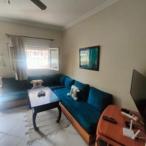 a living room with a blue couch and a table at Studio Relax in Dakhla