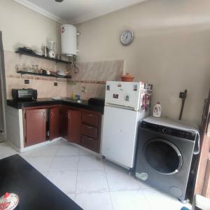 a kitchen with a refrigerator and a washing machine at Studio Relax in Dakhla