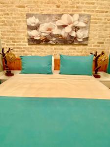 a bed with two blue pillows and a painting on the wall at Antalya Inn Hotel in Antalya