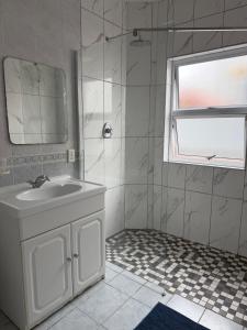 a white bathroom with a sink and a mirror at Nine On Borghorst in Port Elizabeth