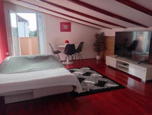 a bedroom with a bed and a flat screen tv at Apartments Benic with a heated pool in Zadar