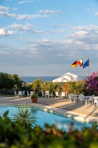 a pool with tables and umbrellas and chairs at Tenuta Querce Grosse- Le Dimore in Francavilla al Mare