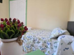 a vase filled with flowers sitting on a table next to a bed at Pensión Restaurante Páramo in La Herradura