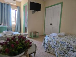 a room with two beds and a tv on the wall at Pensión Restaurante Páramo in La Herradura