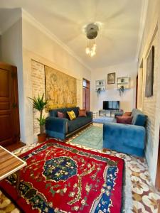 a living room with a blue couch and a red rug at Antalya Inn Hotel in Antalya