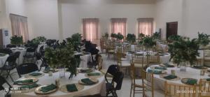 a large room with tables and chairs with plants on them at Golden Alpine Hotel in Yola