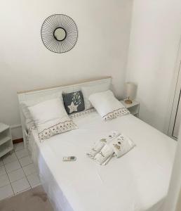 a white bed with two pillows and a mirror at LAKAY SONSON in Les Anses-dʼArlets