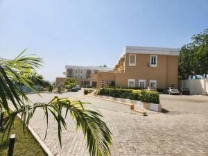 a house with a palm tree in front of a driveway at Golden Alpine Hotel in Yola