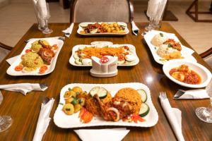 a wooden table with plates of food on it at Golden Alpine Hotel in Yola