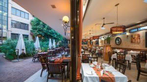 an empty restaurant with tables and chairs and umbrellas at Hotel 33 Kampala in Kampala