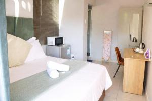 a bedroom with a white bed with towels on it at Sthuli House in Empangeni