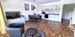 a living room with a kitchen and a table with chairs at Boddenhof Apartment 56 - 2 SZ, freundlich, modern in Buschvitz