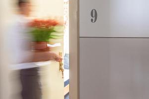 a person is standing next to a door with a plant at Zum Kirchenwirt in Anzing