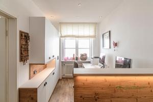 a kitchen with white walls and a counter with a desk at Zum Kirchenwirt in Anzing