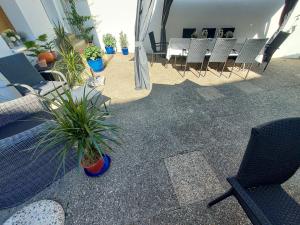 a patio with chairs and a table and plants at Apartmenthaus Schlosspark in Worms +11 photos