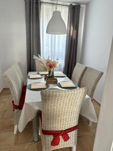 a table with chairs and a vase of flowers on it at Apartmenthaus Schlosspark in Worms