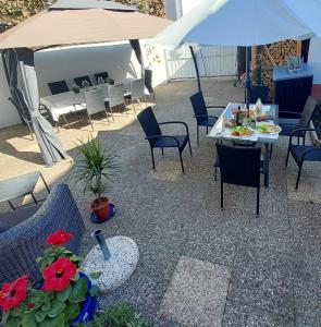 a patio with tables and chairs and an umbrella at Apartmenthaus Schlosspark in Worms
