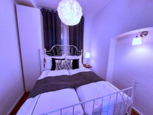 a bedroom with a bed and a chandelier at Apartmenthaus Schlosspark in Worms