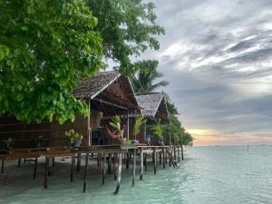 a row of bungalows on a pier in the water at Isiie Homestay in Merpati