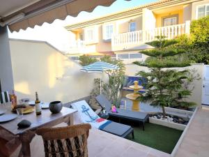 a patio with a table and chairs and a tree at RenTenerife EspebelBeach in El Médano
