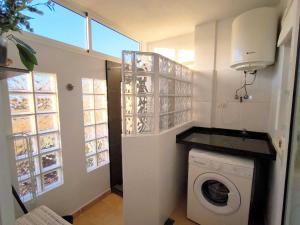 a laundry room with a washing machine and a window at RenTenerife EspebelBeach in El Médano