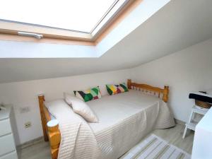 a bedroom with a bed with a skylight at RenTenerife EspebelBeach in El Médano +37 photos