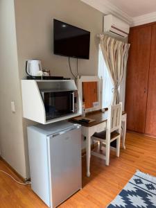 a kitchen with a computer desk with a microwave at Nine On Borghorst in Port Elizabeth