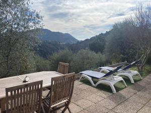 a wooden table and chairs on a patio with a view at Charming apartment with stunning mountain views in Levens