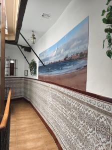 a mural of a beach on the wall in a hallway at Hostal San Francisco in Cádiz
