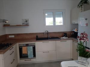 a kitchen with white cabinets and a sink at Caprice des Dunes in Notre-Dame-de-Monts +18 photos