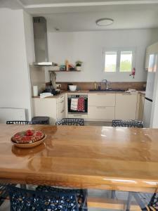 a kitchen with a wooden table with a bowl of fruit on it at Caprice des Dunes in Notre-Dame-de-Monts