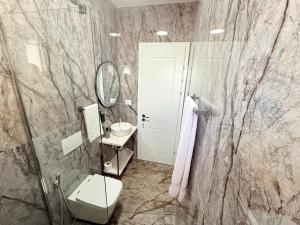 a bathroom with a toilet and a sink and a mirror at Citrus Nest in Berat +25 photos