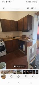 a kitchen with wooden cabinets and a white chair at Rafa y Nelly 2 in San Clemente del Tuyú