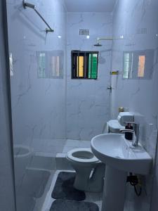 a white bathroom with a sink and a toilet at Elvara's Nest in Lusaka +12 photos