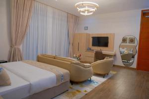 a bedroom with a bed and a desk and a television at The Lemiray Hotel in Dodoma