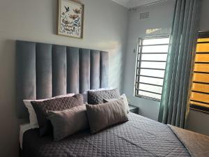 a bedroom with a large bed and a window at Elvara's Nest in Lusaka