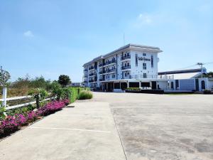a large white building with flowers in front of it at โคโค่ โฮเทล KOCO Hotel in Nakhon Ratchasima
